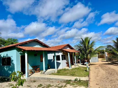 a blue house on the side of a dirt road at pousada chales vale do catimbau in Buíque