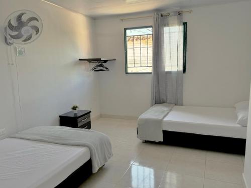een slaapkamer met twee bedden en een raam bij Los Nonos Hostel in Guadalupe