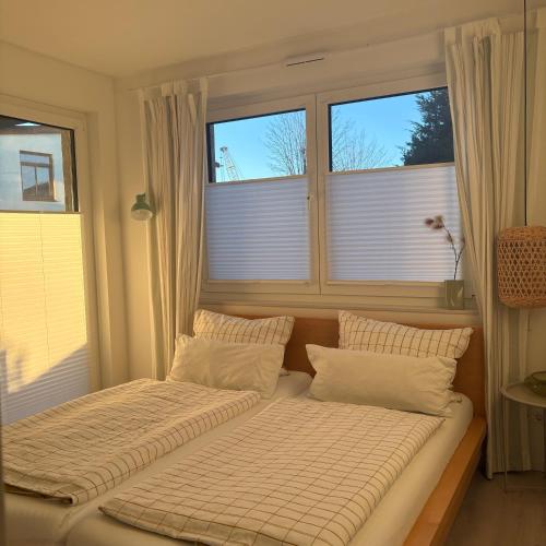 two beds in a room with two windows at Cosyinlaboe in Laboe