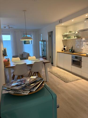a kitchen and living room with a table and chairs at Cosyinlaboe in Laboe