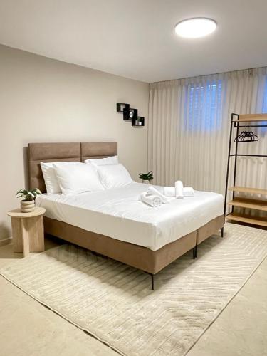 a bedroom with a large bed with white sheets at Ramon Palms in Mitzpe Ramon