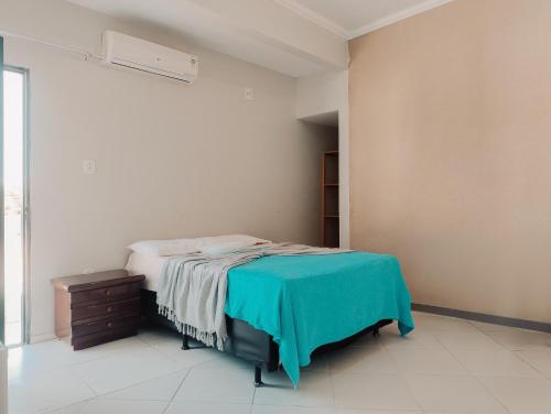 een slaapkamer met een bed met een blauwe deken erop bij Hotel A BARCA in Bom Jesus da Lapa