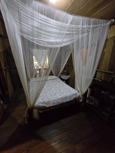 a bedroom with a bed with a mosquito net at Landscape-Cabaña winter full equipada in La Cruz