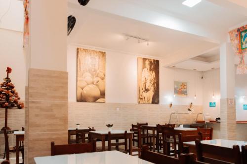 een eetkamer met tafels en stoelen en schilderijen aan de muren bij Hotel A BARCA in Bom Jesus da Lapa