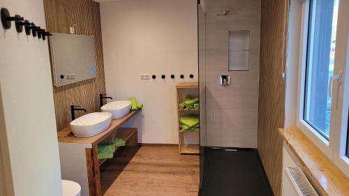 a bathroom with two sinks and a shower at Ferienappartement Talblick in Hohnstein