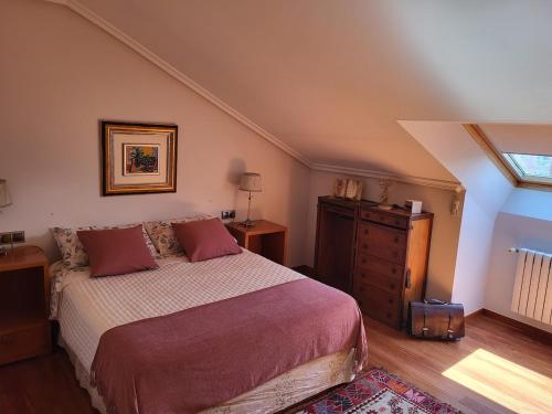 a bedroom with a bed and a dresser and a window at O lar da luz in Ourense
