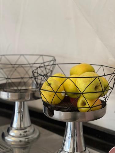 a bowl of lemons and pears on a metal stand at RUM NADINE LUXURY CAMP & Bubbles Hotel in Wadi Rum