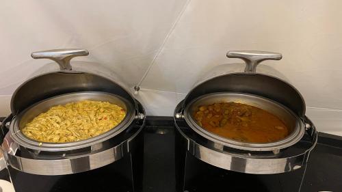 two pots filled with food on top of a stove at RUM NADINE LUXURY CAMP & Bubbles Hotel in Wadi Rum