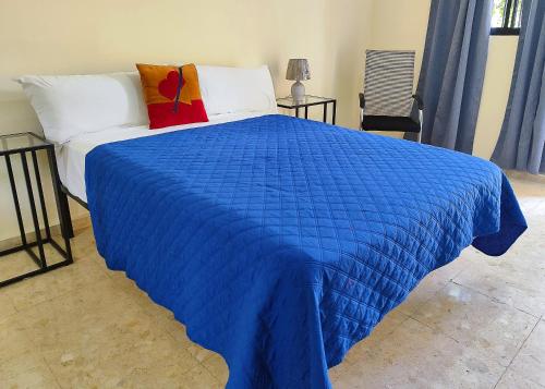 een blauwe deken op een bed in een slaapkamer bij Refugio Encantador in Santo Domingo