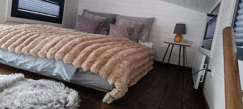 una camera da letto con un letto con una coperta sopra di Zajazd Józef Tiny House a Witów