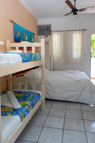 a bedroom with two bunk beds and a ceiling fan at Pousada do Rei in Ubatuba