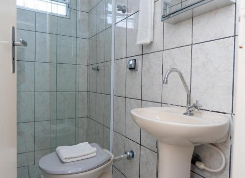 un bagno bianco con lavandino e WC di Pousada do Rei a Ubatuba