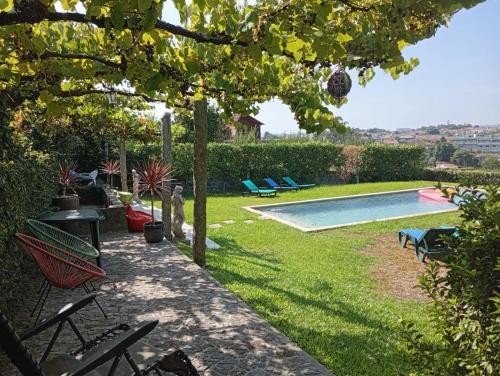 a backyard with a swimming pool and chairs at Casa com Piscina Privada de 10m e Jardim, até 8 pessoas, perto do Porto in Landim