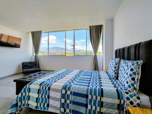ein Schlafzimmer mit einem Bett und einem großen Fenster in der Unterkunft BISÁU Hotel in Ruiosucio
