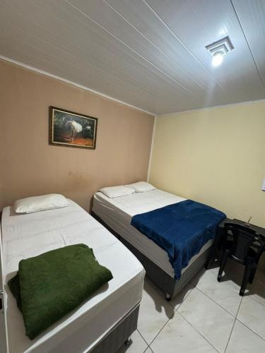 a bedroom with two beds and a desk with a computer at POUSADA DEUS É FIEL Coruripe in Coruripe