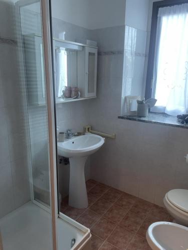 a bathroom with a sink and a toilet and a shower at La casa di Mimo in Nesso