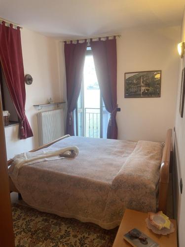 a bedroom with a large bed and a window at La casa di Mimo in Nesso