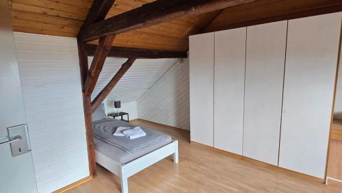 a bedroom with white cabinets and a bed in a attic at Room 4 - shared house in Linz am Rhein