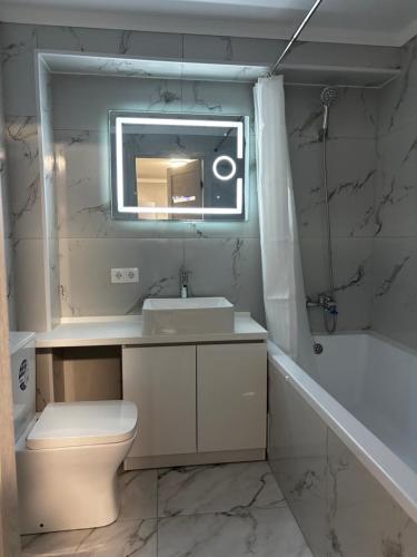 a bathroom with a sink and a toilet and a mirror at New apartment Căușeni in Căuşeni