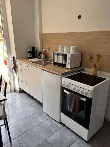 een keuken met een fornuis en een magnetron bij Chez Aurore in Port-de-Bouc