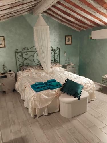 a bedroom with a large bed and a chair at La casa di baggioro in Castelvecchio