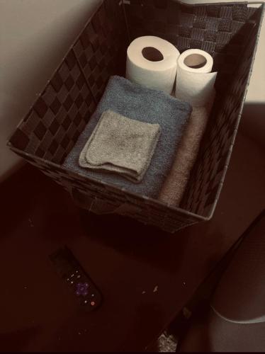 a basket with two rolls of toilet paper and towels at McDaniel House Private Room 6 Shared Bathroom in Atlanta