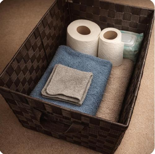 a basket with two rolls of toilet paper and towels at McDaniel House Private Room 6 Shared Bathroom in Atlanta