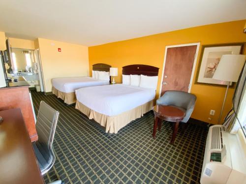 a hotel room with two beds and a chair at Travelinn in Unadilla