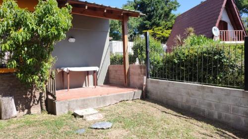 a backyard with a fence and a chair on a porch at Amistad in Villa Gesell