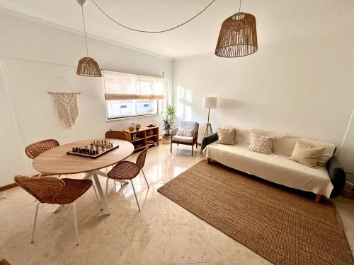 een woonkamer met een bank en een tafel bij Miguel Surf House in Costa da Caparica