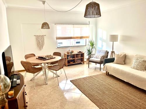 een woonkamer met een tafel en een bank bij Miguel Surf House in Costa da Caparica
