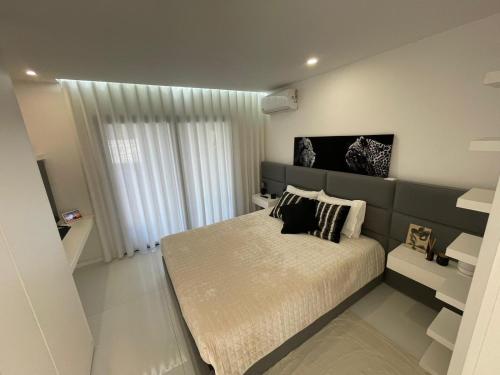 a bedroom with a large bed and a window at Vila do Sol in Figueiredo