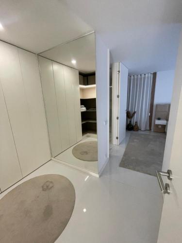 a white room with a large mirror on the floor at Vila do Sol in Figueiredo