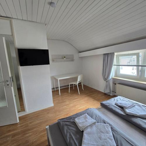 a bedroom with a bed and a table in it at Room 3 - shared house in Linz am Rhein