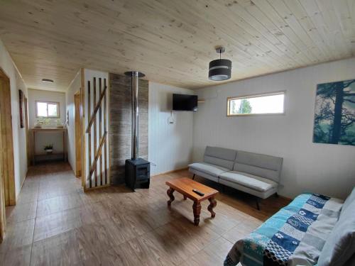 a living room with a couch and a table at Cabaña 3 Aeropuerto el Tepual in Puerto Montt