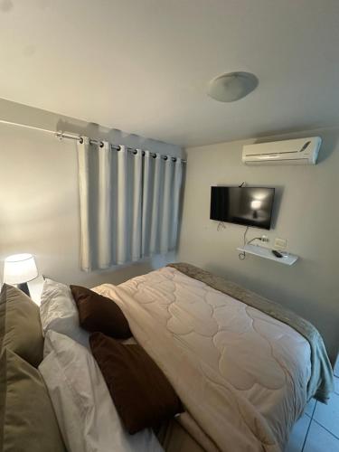 Edf Monte Valpine في ماسيو: غرفة نوم بها سرير وتلفزيون على الحائط