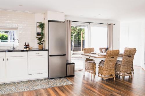a kitchen with a refrigerator and a table with chairs at Boshuisje de Kastanje - Chalet met prive hottub in Putten