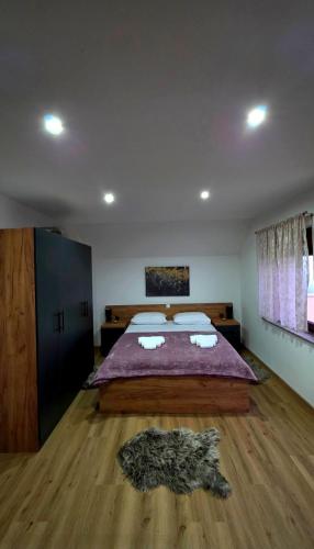 a bedroom with a large bed with a purple blanket at Kuća za odmor Vista in Slavonski Brod