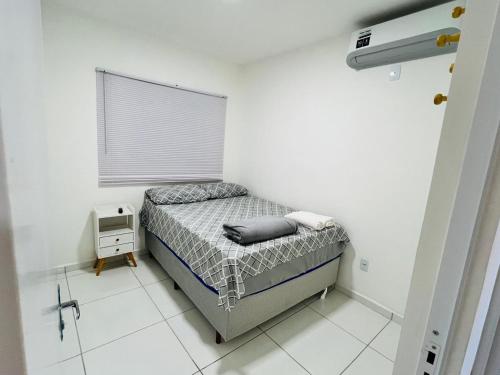 a small bedroom with a bed and a window at Casa duplex em condomínio Parnaiba in Parnaíba