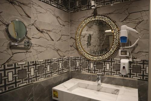 een badkamer met een wastafel en een spiegel bij LUSINDA HOTEL MANAGEMENT BY ZAD in Suez