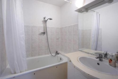 a bathroom with a tub and a sink and a shower at Au pied des pistes (Le Corbier/73) in Villarembert