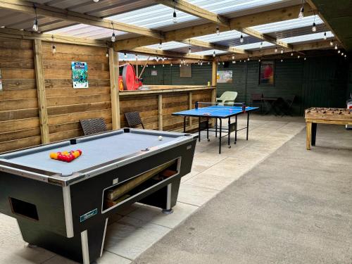 a room with a pool table and two tables at The Beehive in Narberth
