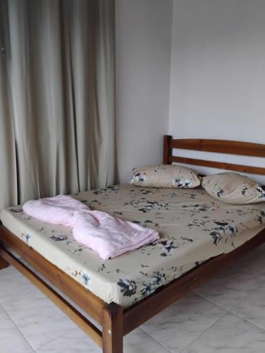 a bed with two pillows on it in a bedroom at Aconchego Maria Laura in Palhoça