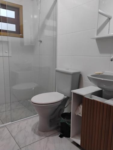 a bathroom with a toilet and a shower and a sink at Aconchego Maria Laura in Palhoça