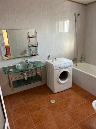 a bathroom with a washing machine and a sink at Home Lenda in Tarrafal