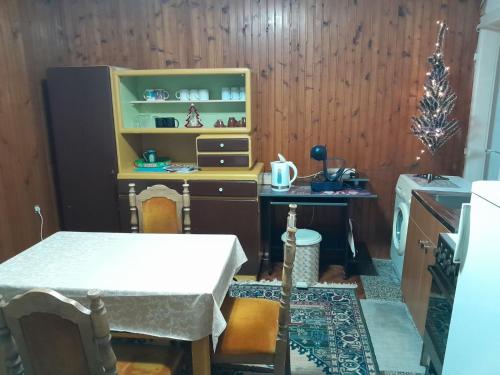 eine Küche mit einem Tisch und einem Tisch und einem Regal in der Unterkunft Triangle in Sarajevo