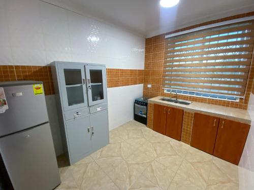 eine Küche mit Kühlschrank und Spüle in der Unterkunft Somerset Apartmento in Tokuse