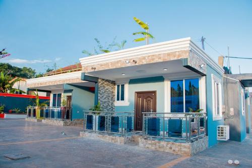 ein blau-weißes Haus mit einem Balkon in der Unterkunft Somerset Apartmento in Tokuse