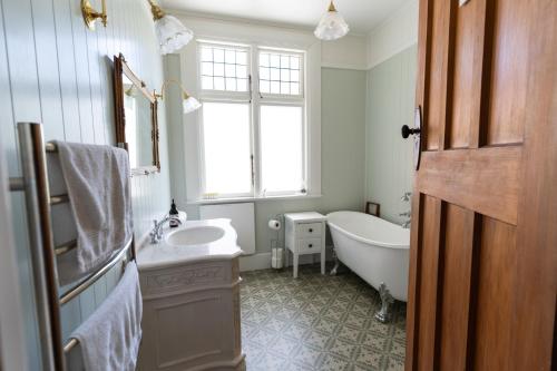 een badkamer met een bad en een wastafel en een ligbad bij Hemsworth Estate in Elgin