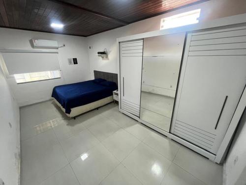 a bedroom with a blue bed and a sliding glass door at Casa de Temporada, 2 Quartos com Ar - Prado BA in Prado